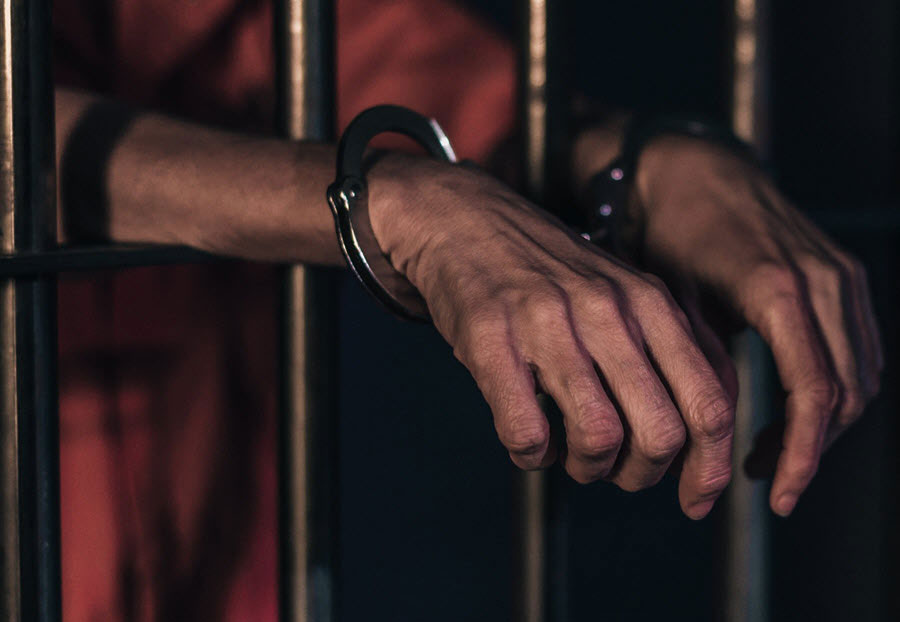 man in prison wearing hand cuffs