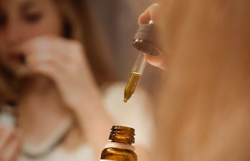 woman taking cbd oil for her health